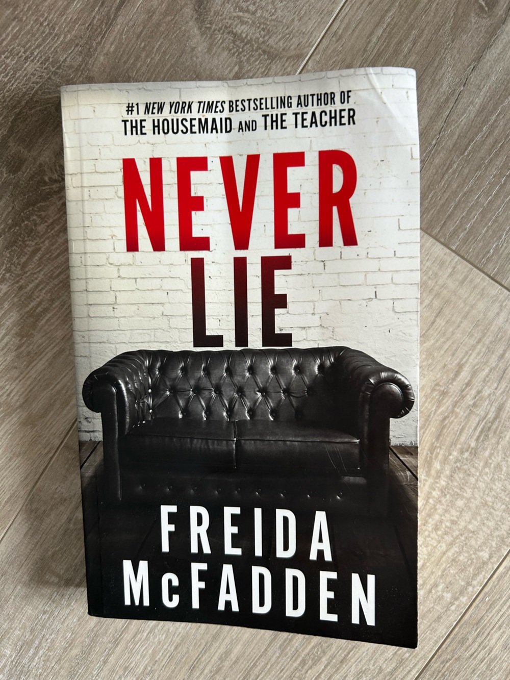 Never Lie Book with Black Leather Sofa Cover Art